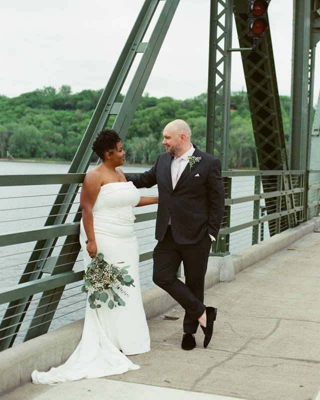 Mari and Jonathan&rsquo;s romantic summer elopement at Lowell Park Gazebo in Stillwater, Minnesota &mdash; captured on film by Lulle Photo and Film associate photographer Sam. The bride, wearing a stunning Luxe Bridal gown with soft makeup by Faces by Fionna and florals from Trader Joe&rsquo;s, stands beside the groom in a classic Menswearhouse suit. Their Arthur&rsquo;s Jewelers wedding rings glimmer in the warm golden light, surrounded by natural greenery and vintage-inspired tones. The soft, timeless film aesthetic gives each image a dreamy, nostalgic feel &mdash; perfect for couples seeking elegant, intimate wedding inspiration in Minnesota.
